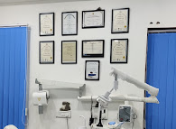 Dr. Amrata's dental certifications and diplomas displayed on clinic wall